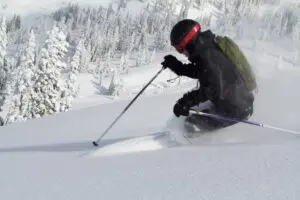 a skier goes down a slope in waist deep powder