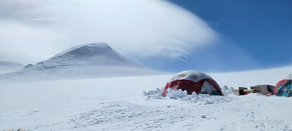 a view of an ice core drilling expedition on the summit plateau of Mount Logan with Prospector Peak in the background